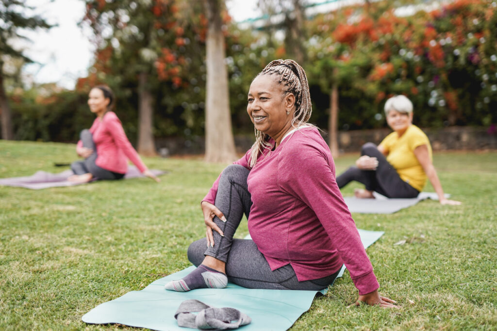 A woman practices yoga in a public park. Utilize EAM software to provide your community the best resources possible.